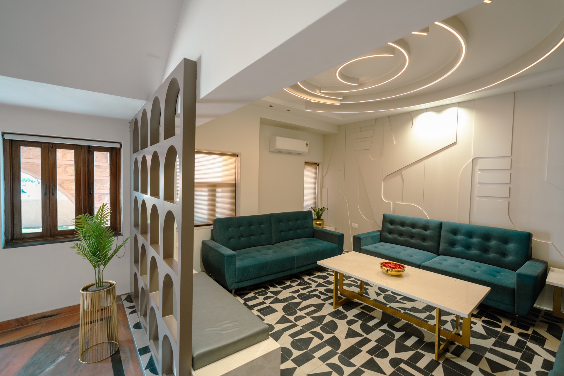 The lobby at Hotel Ramdev — teal sofas, patterned tile floor, and an arched screen